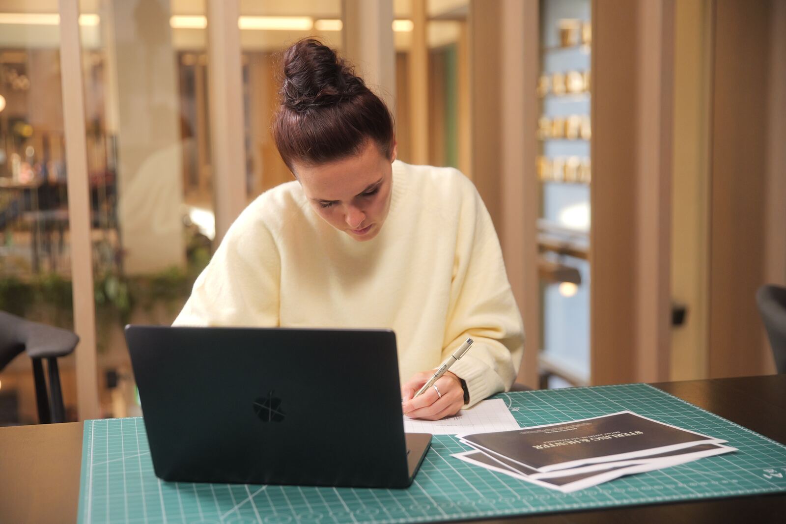 Designer working at a laptop on a cutting mat