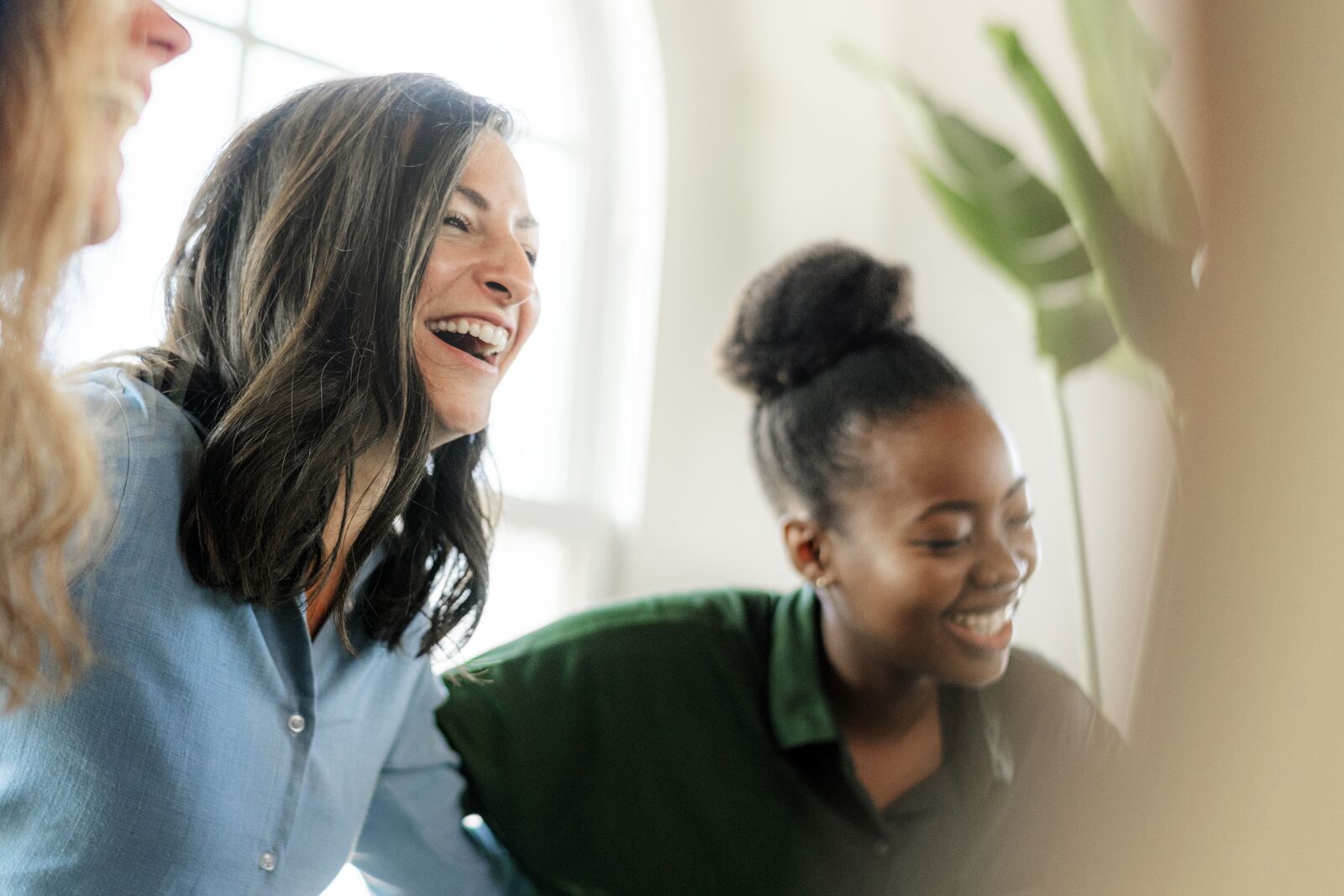 Two colleagues laughing in a bright office